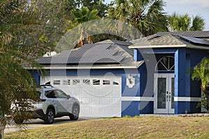 Car parked in front of wide garage double door on concrete driveway of new modern american house