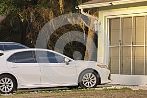 Car parked in front of wide garage double door on concrete driveway of new modern american house