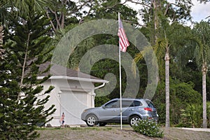 Car parked in front of wide garage double door on concrete driveway of new modern american house