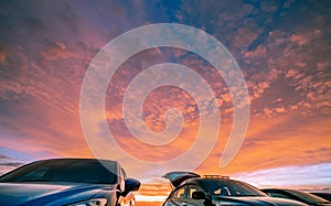 Car parked at outdoor car parking lot of campsite with beautiful sunset sky. Car drive for adventure road trip. Nature landscape.