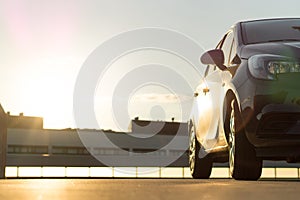 Car parked in parking lot on roof in summer time sunset