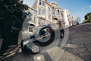 Car parked safely with turned wheels on slanted street in San Francisco.