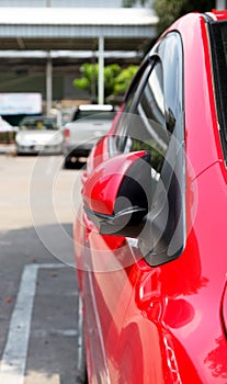 Car parking with side rear-view mirror closed for safety