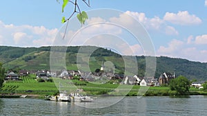 Car and passenger ferry from Ellenz towards Beilstein at Moselle River. View over vineyards