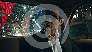 Car passenger resting vehicle at evening closeup. Model guy looking rain window