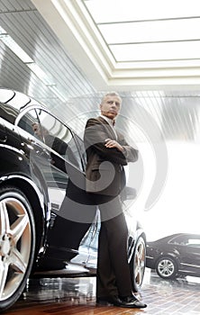 This car is perfect for me. Confident senior businessman leaning