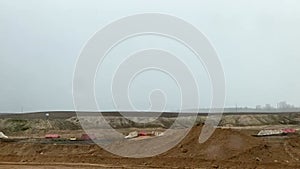 Car point of view driving past repair roadworks, heavy plant machinery in use, speed restrictions apply. Minsk, Belarus