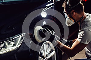 Car polish wax. worker hands holding a polisher