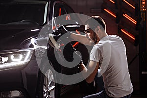 Car polish wax. worker hands holding a polisher