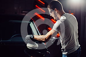 Car polish wax. worker hands holding a polisher photo