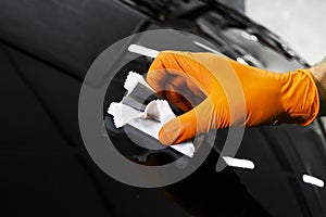 Car polish wax worker hands polishing car. Buffing and polishing vehicle. Car detailing. Man holds a polisher in the hand and poli photo