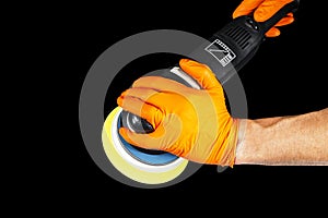 Car polish wax worker hands withs tools isolated on black background. Buffing and polishing. Car detailing. Man holds a polisher i