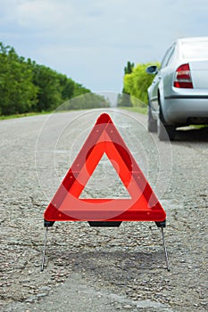 Car with problems and a red triangle to warn other road users