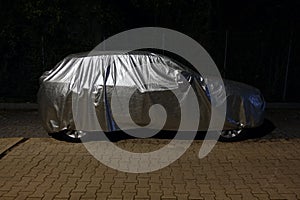 Car with protective cover at night