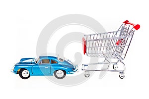 Car pulling shopping cart conceptual image isolated on white background