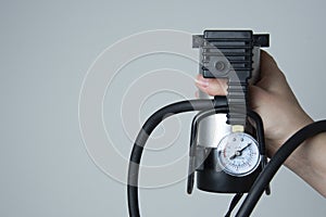 Car pump auto air compressor isolated on the white background. Hand holding, showing. Car care