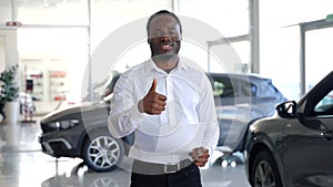 Car purchase in dealership. Black salesman in car showroom