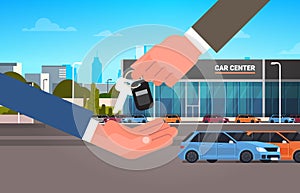 Car Purchase Sale Or Rental Concept, Seller Man Hand Giving Keys To Owner Showroom Center Background