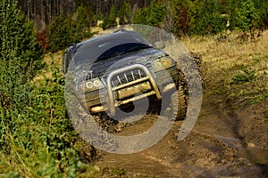 Car racing in autumn forest. Off road vehicle or SUV overcomes obstacles. Competition, energy and motorsport concept