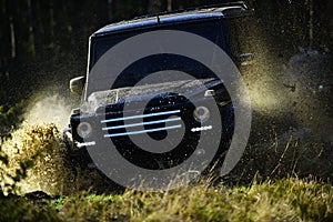 Car racing in autumn forest. Offroad race on fall nature background. Extreme, challenge and 4x4 vehicle concept. SUV or