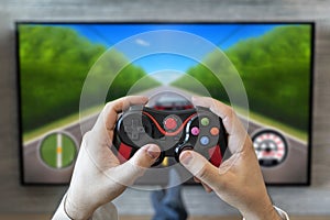 car racing simulator. gaming gameplay tv. fun game on gamepad. game controller video console playing player holding. hobby playful