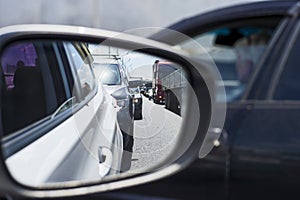 Car rear view mirror with reflection of the traffic flow in the tube. Concept: modern rhythm of life