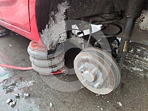 Car with rear wheel removed, lifted by hydraulic jack, car repair on the roadside