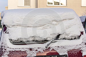 Car rear window covered with a large layer of snow, car covered with snow