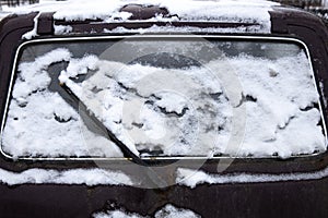 Car rear window with a janitor in the snow