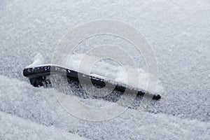 car rear windshield and wiper waterblade frozen and covered with snow at winter cloudy day light