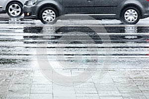 Car reflecting in wet asphalt road during rainy weather