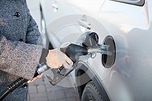 Car refueling on petrol station. Fuel pump with diesel, female hand inserting pistol in car petrol tank