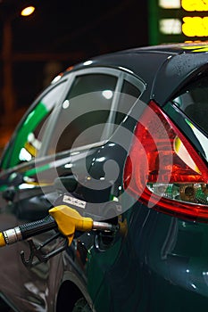 Car refueling on a petrol station in winter at night