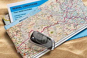 Car remote key on map and rental agreement