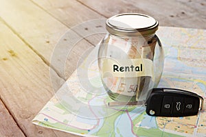 Car rent - money glass, car key and roadmap