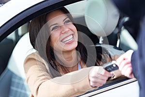 Car rental agency employee giving car keys to beautiful young woman.