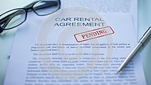 Car rental agreement pending, officials hand stamping seal on business document