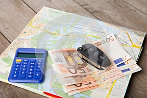 Car rental concept - car key,calc, and money on the map photo
