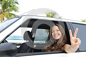 Car rental: happy woman in her car near the beach