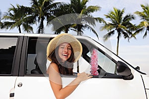 Car rental: happy woman in her car near the beach