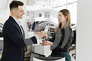 Car rental and Insurance concept, Young salesman receiving money and giving car`s key to customer after sign agreement