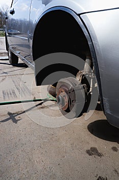 Car repair. Car with removed wheels on pneumatic jacks. View of the brake discs hub