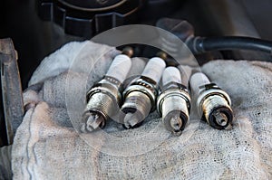 Car repair. Replacing spark plugs. Old spent candles covered with soot