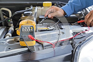 Car repair service, Auto mechanic checking a car battery level