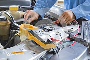 Car repair service, Auto mechanic checking a car battery level