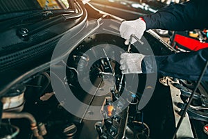 Car Repair service, Auto mechanic working in garage, Mechanic hands checking up of serviceability of the car in open hood, close