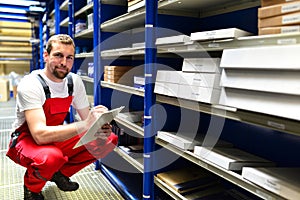 Car repair shop employees in the warehouse for spare parts for r