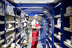 Car repair shop employees in the warehouse for spare parts for r