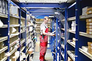 Car repair shop employees in the warehouse for spare parts for r