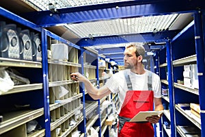 Car repair shop employees in the warehouse for spare parts for r